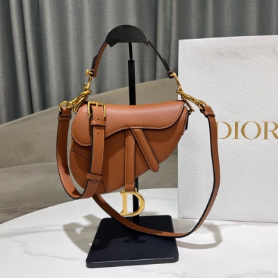 Dior迪奧 馬鞍包 M0059小號 焦糖色粒面牛皮革 這款馬鞍包突顯瑪麗亞·嘉茜婭·蔻麗 (Maria Grazia Chiuri) 的巧妙設計。採用焦糖色粒面牛皮革精心製作，馬鐙D形吊飾和馬鞍翻蓋彰顯經典設計，手柄兩側飾以復古金色飾面金