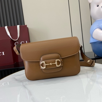 Gucci古馳 新品 這款Gucci Horsebit 1955系列小號肩背包延續馬術風格，搭配雙環和長條形設計，巧妙融合淺金色調細節與光面牛皮革。棕色光面牛皮革搭配撞色縫線 淺金色調配件 棕色棉麻混紡襯裡 正面飾馬銜扣細節 兩側飾半馬銜扣