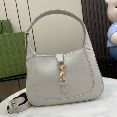 Gucci古馳 新品 Jackie系列小號肩背包。這款全新Gucci Jackie系列肩背包以上等優質皮革匠心打造，盡展品牌經典肩背包的精湛工藝、新月造型和時尚設計。淺金色調配件、皮革滾邊和飾有紅綠織帶的附贈包帶結合，為這款以酒紅色漆皮打造