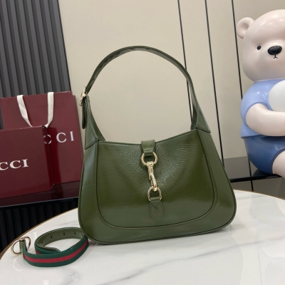 Gucci古馳 新品 Jackie系列小號肩背包採用森林綠漆皮材質，配有淺金色調鉤扣和附贈包帶，閃耀2025春夏系列。森林綠漆皮 淺金色調配件 深綠色皮革襯裡 內部：一個拉鍊袋，飾Gucci徽章拉鍊頭 提手（18釐米高）可拆卸織帶肩帶（52