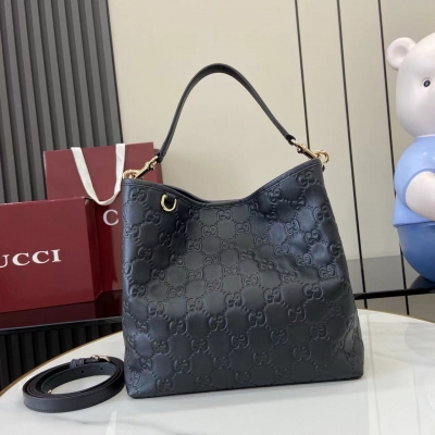 Gucci古馳 新品 GG Emblem系列煥新詮釋品牌的雋永優雅風範和精湛工藝。這款水桶包採用織帶棉質襯裡，設有一個內部隔層，實用性出眾。黑色GG印花壓紋皮革 淺金色調配件 黑色棉麻混紡襯裡 鉤扣開合頂部提手（高度：18釐米）另配有用於系