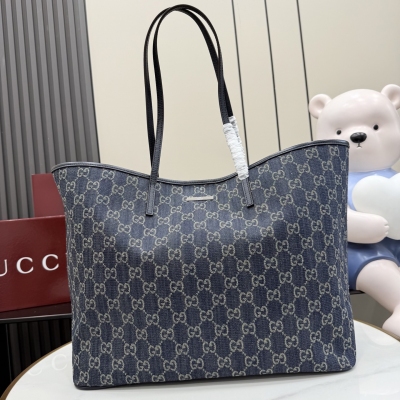 Gucci古馳 Generation Gucci系列深入探索品牌的典藏元素，將不同世代的設計融入一個美學敘事中。GG牛仔布搭配品牌標識徽牌，為精緻廓形增添標誌性細節。這款托特包提升了日常風格，內部配有拉鍊口袋。深藍色水洗GG牛仔布 深藍色皮